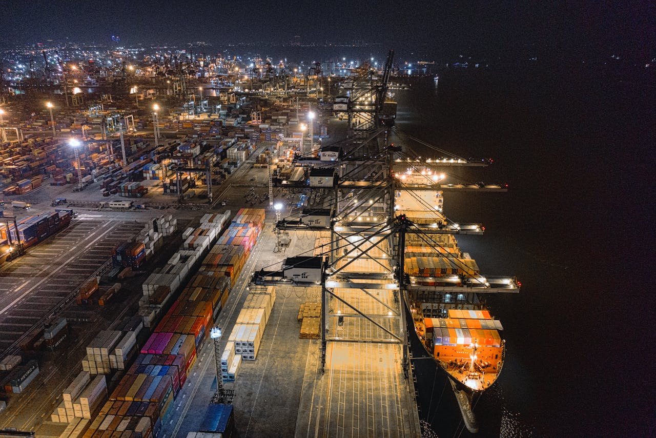 heros-img A captivating aerial view of Jakarta's bustling shipping port at night, showcasing vibrant activity.