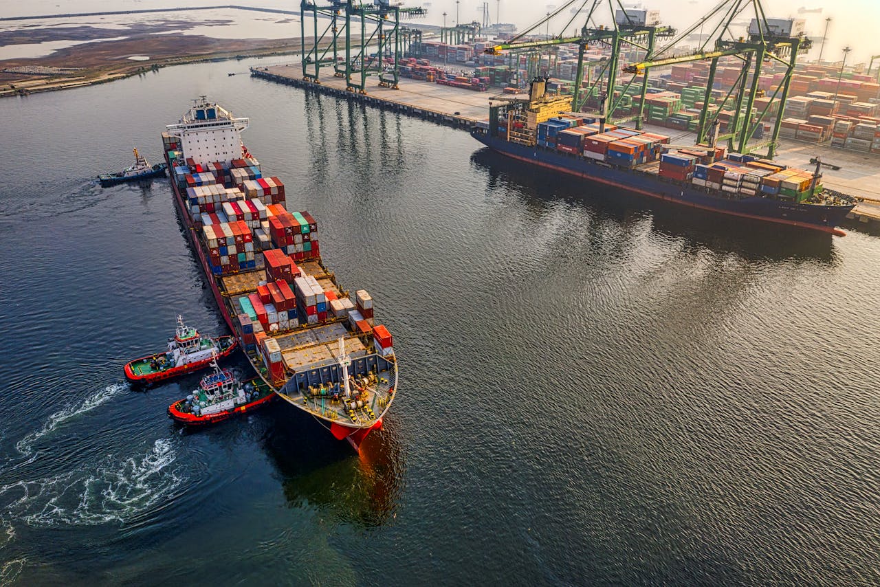 about-us Aerial shot of cargo ships and cranes at North Jakarta port, showcasing global shipping and logistics.